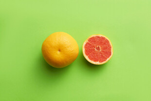 绿背景上的完整与半颗西柚