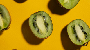 黄色背景上的切开猕猴桃