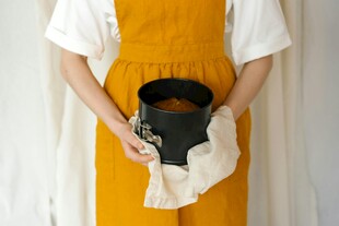 女子手持黑色容器与布