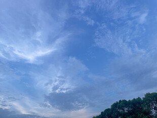 蓝天飘云下的山峦景色