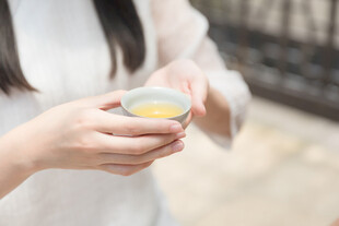 女子手持茶盏品茶