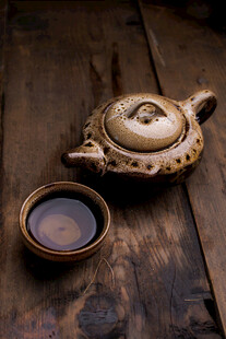 古朴茶壶与茶盏置于木桌