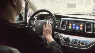 驾驶员手握方向盘操作中控