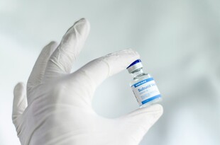 手戴手套持小瓶药剂