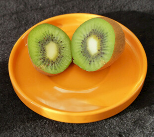 橙色盘上的两半新鲜猕猴桃