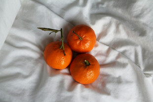 白布上的三颗新鲜橘子