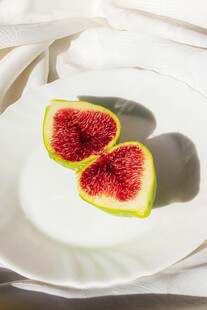 白色盘上的两半新鲜无花果