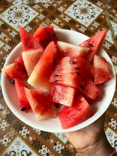 手捧盘中新鲜切块西瓜
