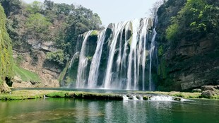 壮丽瀑布下的碧绿潭水