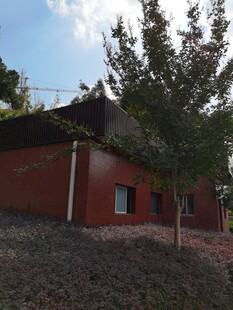 红墙绿树旁的小屋