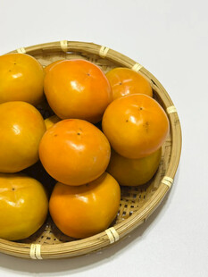 竹篮中的圆润橙黄柿子