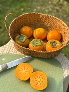 竹篮中的新鲜柿子及切片