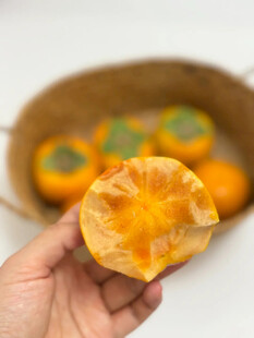 手捧剥开的香甜柿子