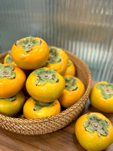 竹篮中的新鲜甜柿子