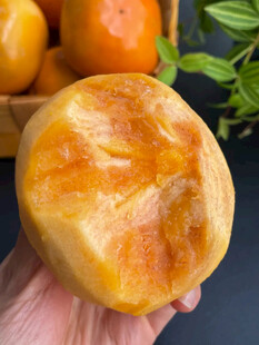 手捧金黄诱人的脆甜柿子