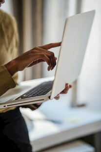 手操作打开的白色笔记本电脑