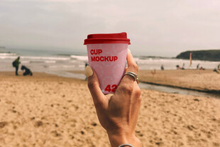 沙滩上手持咖啡杯的惬意时刻