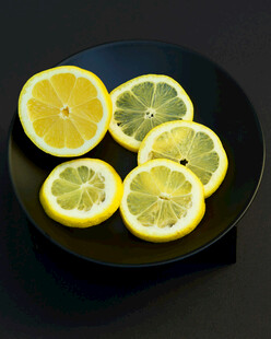 黑色盘上的新鲜柠檬切片