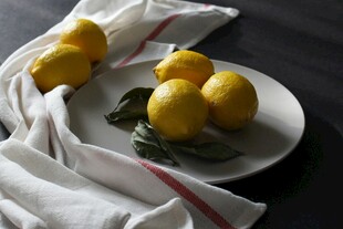 白盘上的新鲜柠檬与布