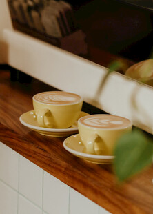 两杯咖啡置于木桌之上