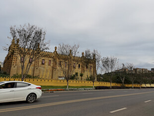 路边古老建筑与白色轿车