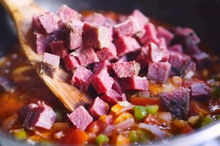 木勺舀起锅中牛肉块