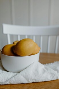 木桌上白碗中的黄梨