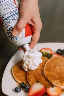 往松饼上挤奶油的瞬间