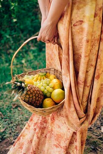 女子提篮盛着多彩水果