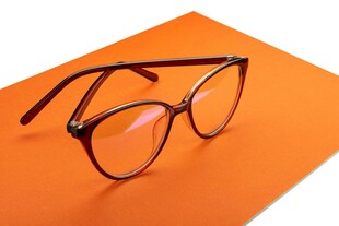 橙色背景上的时尚黑框眼镜