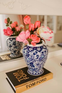 蓝白瓷瓶插粉花置于书旁