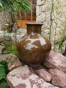 古朴陶罐置于石堆之上