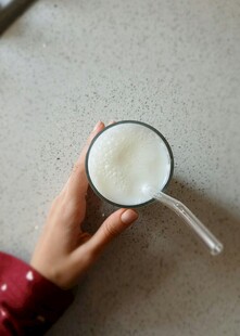 手持玻璃杯中的白色饮品