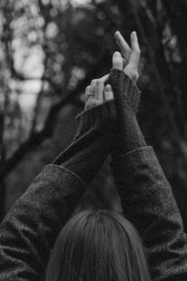 女孩双手比心于林间