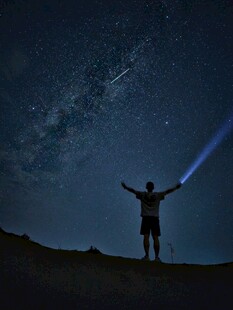 星空下张开双臂的旅人
