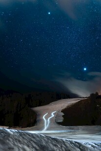 雪夜星空下的蜿蜒道路
