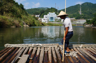 竹筏上撑篙的乡村男子