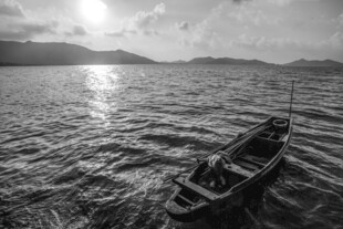 孤舟泛于波光粼粼湖面