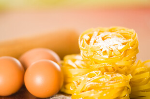 鸡蛋与黄色面食堆叠场景