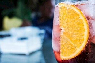 手持橙片的饮品特写