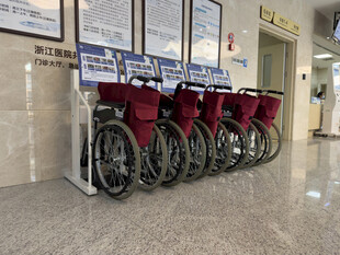 医院墙边整齐摆放的轮椅