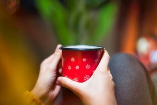 双手捧红色杯子温馨画面