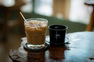 木桌上的冰咖啡与小杯