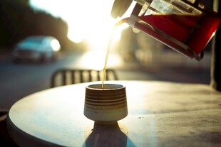 夕阳下桌边的咖啡倾倒瞬间