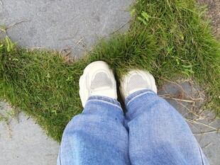 双脚立于草地与路面间
