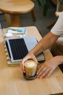 手捧咖啡于桌前惬意办公