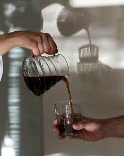 手冲咖啡倒入玻璃杯瞬间