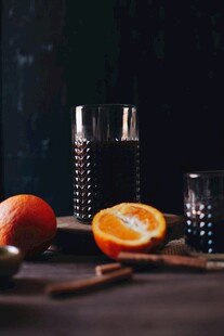 深色背景下的橙子与玻璃杯