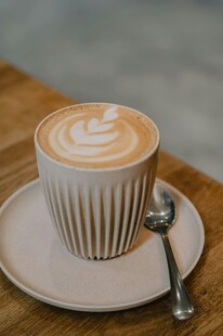 精致拉花咖啡置于木桌