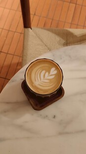 精致拉花咖啡置于木桌